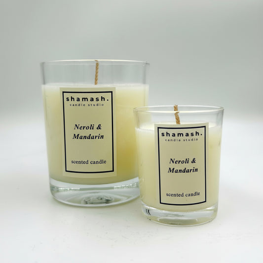 Two shamash candle studio candles labeled 'Neroli & Mandarin' on a white background